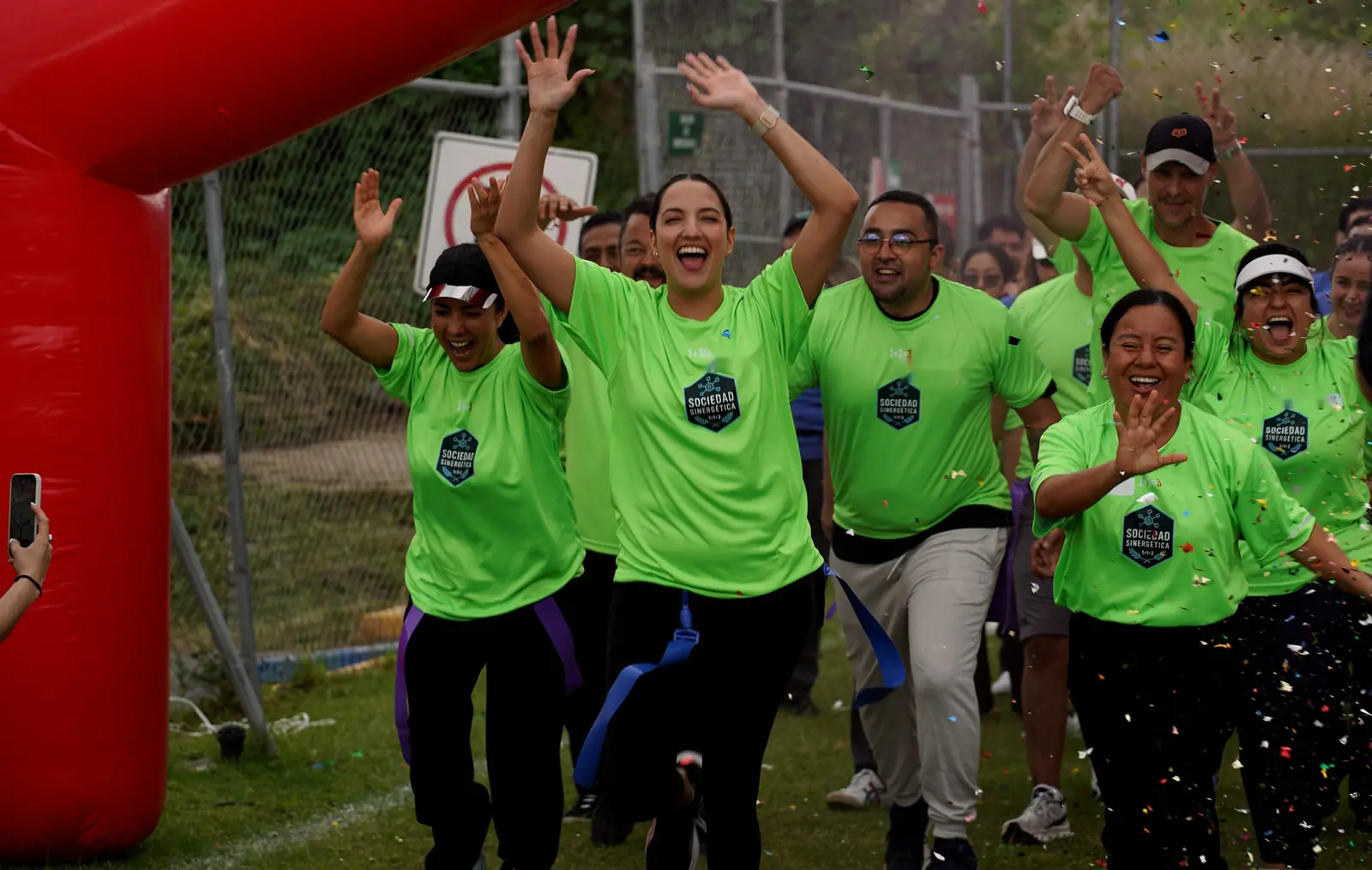 Un equipo del MAS entra corriendo por el arco inflable entre confeti, con los brazos arriba