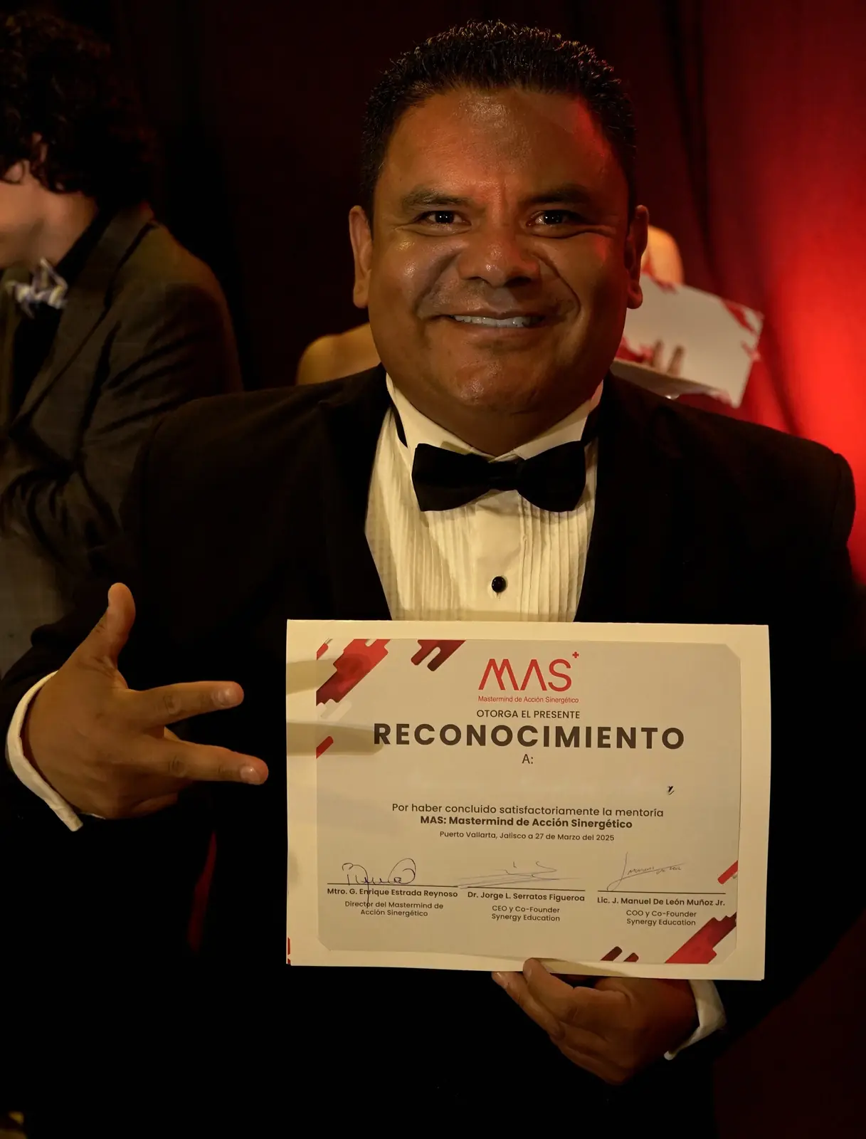 Un graduado del MAS de smoking muestra orgulloso su reconocimiento en la gala de Vallarta
